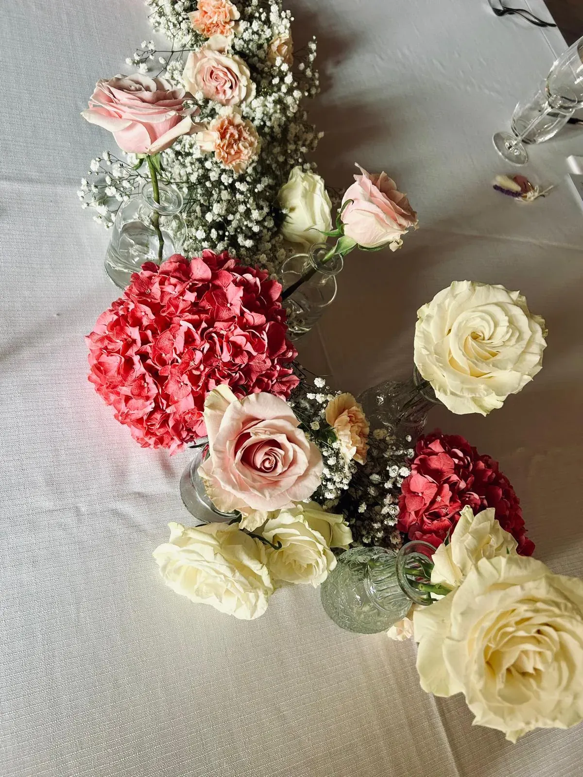 Centrotavola con rose e piccoli fiori bianchi