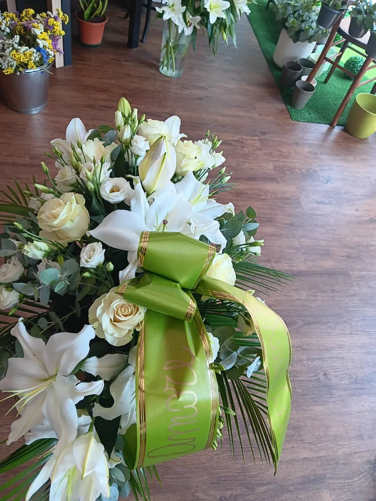 Composizione funebre bianca con nastro verde