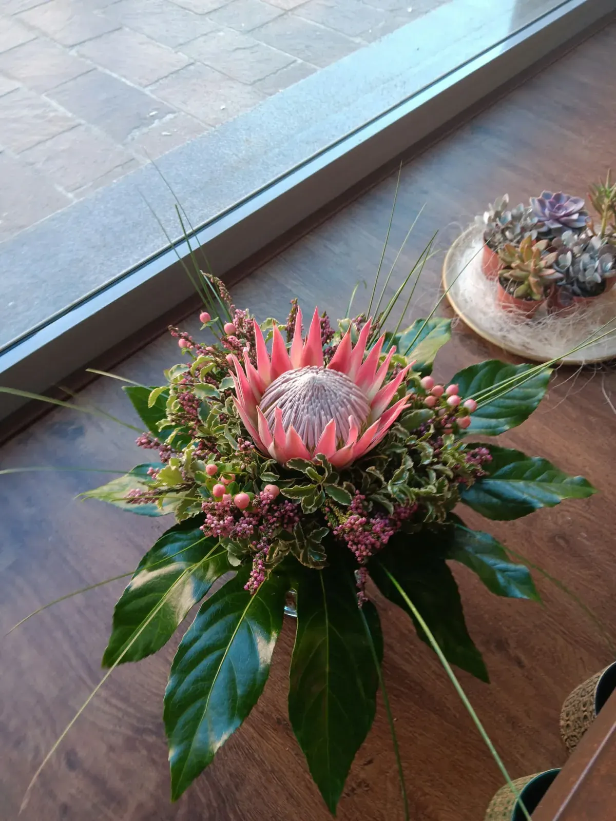 Bouquet con protea rosa e verde decorativo