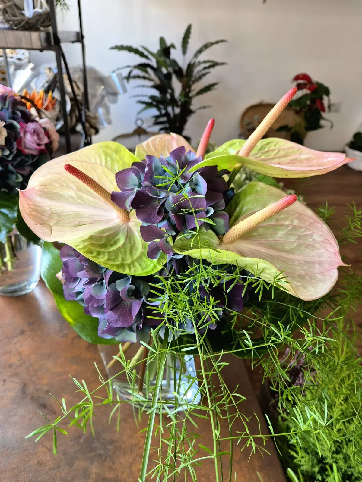 Bouquet con anthurium rosa e fiori viola