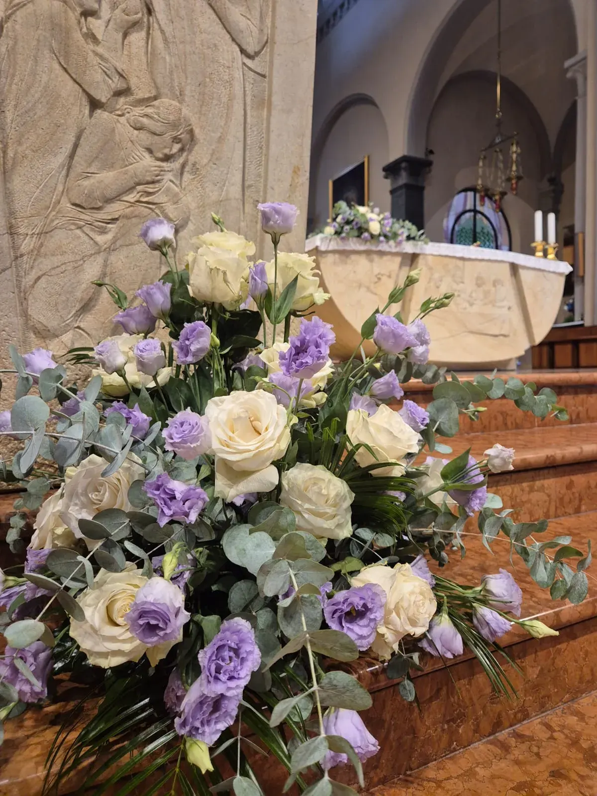 Composizione di rose bianche e lilla in chiesa