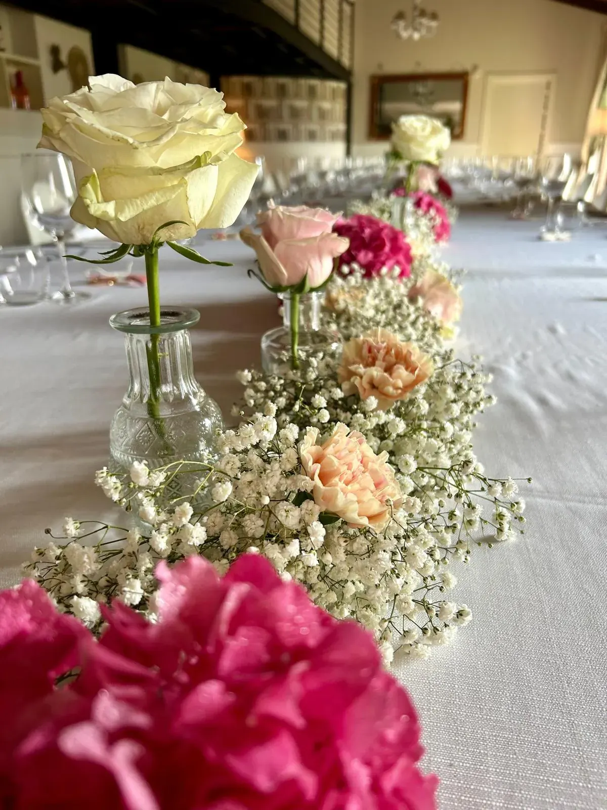 Decorazione della tavola con rose e piccoli fiori bianchi