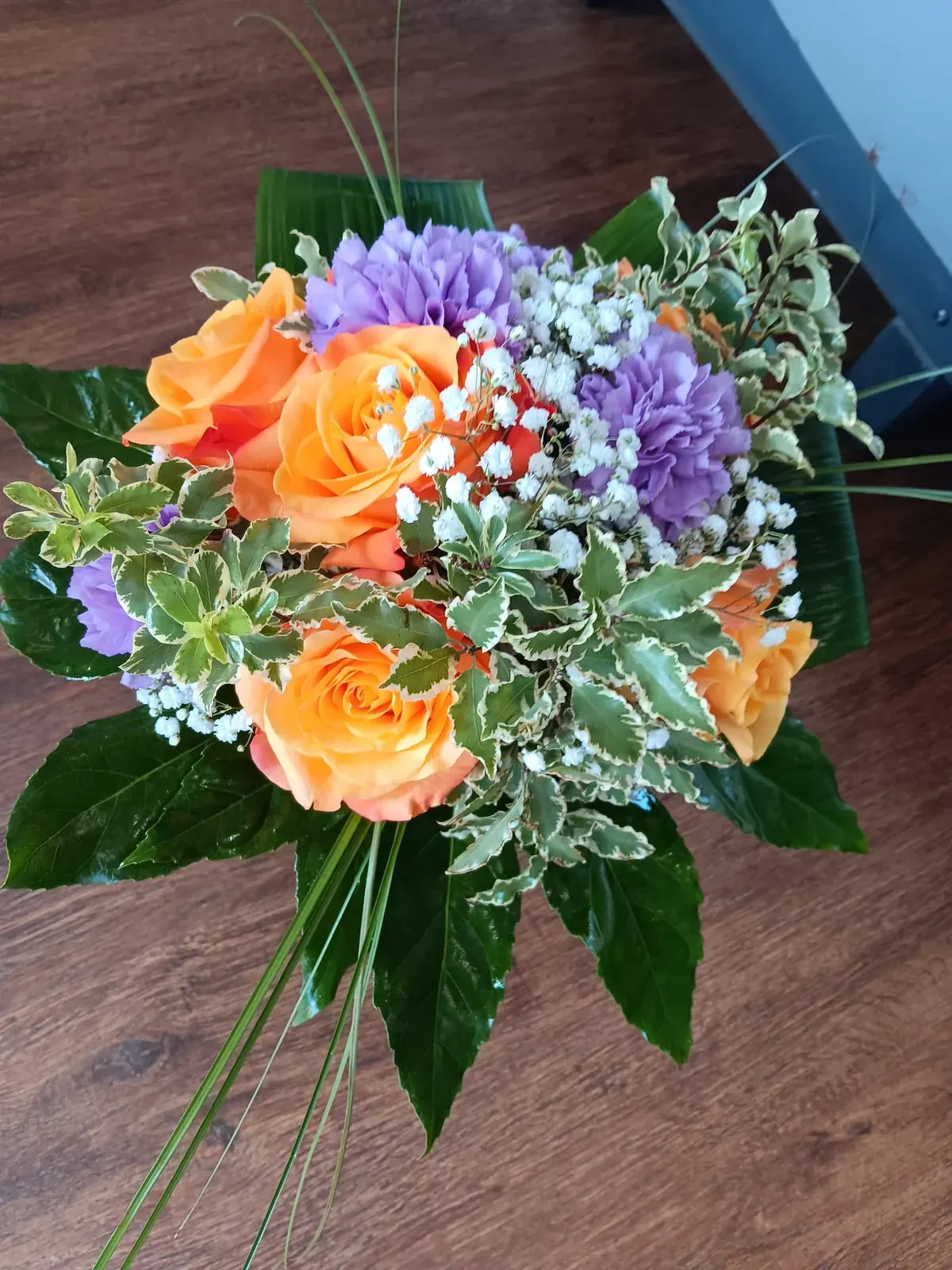Bouquet con rose arancioni e piccoli fiori viola