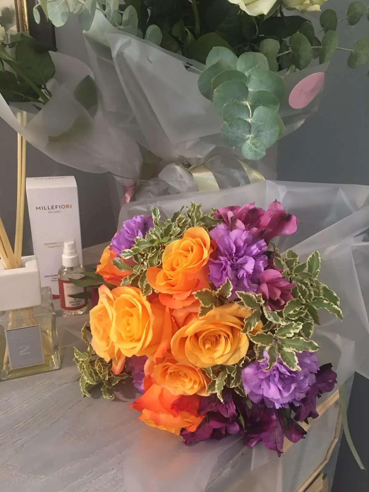 Bouquet arancione e viola avvolto nella carta