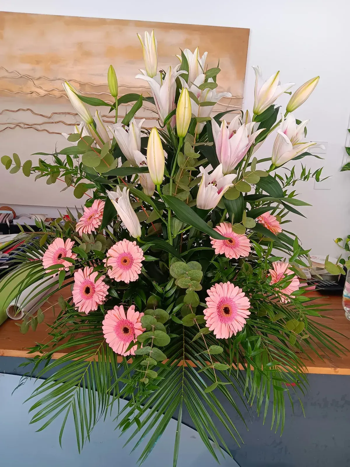 Composizione funebre con gigli e gerbere rosa