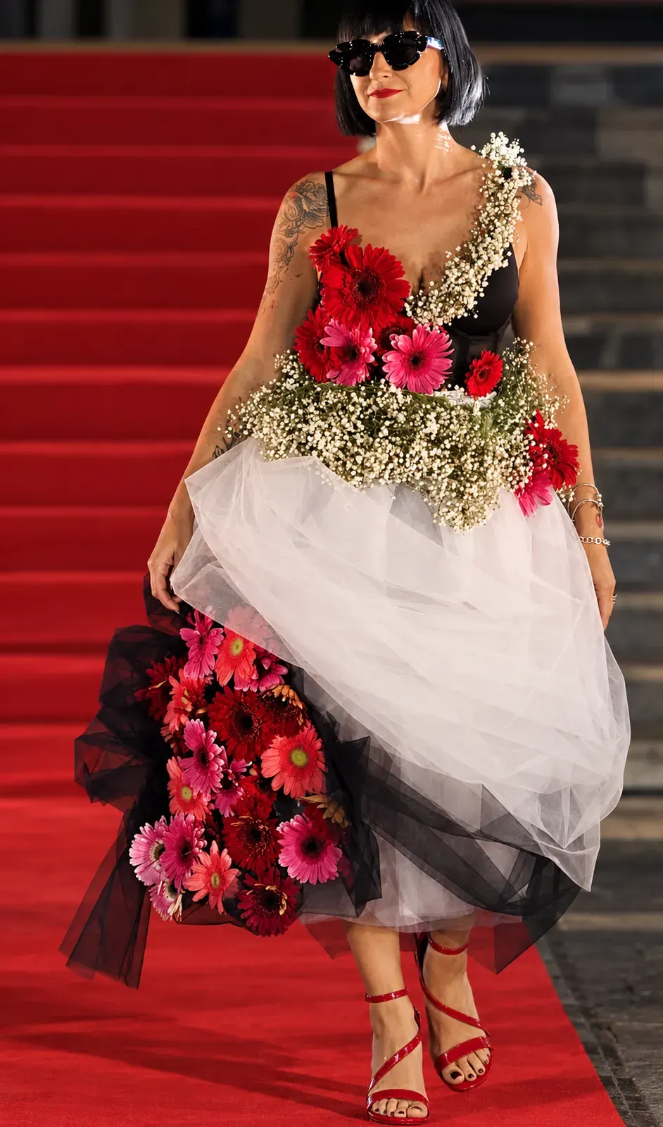 Abito con rose rosse su una scalinata