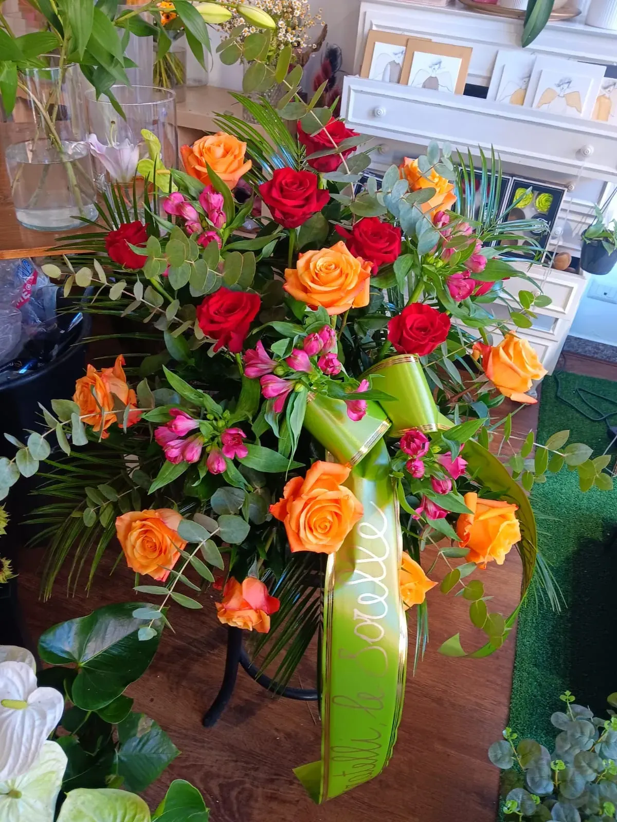 Composizione funebre di rose rosse e arancioni