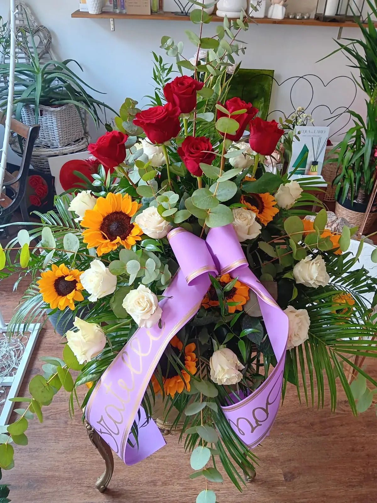 Composizione funebre con rose rosse e nastro lilla
