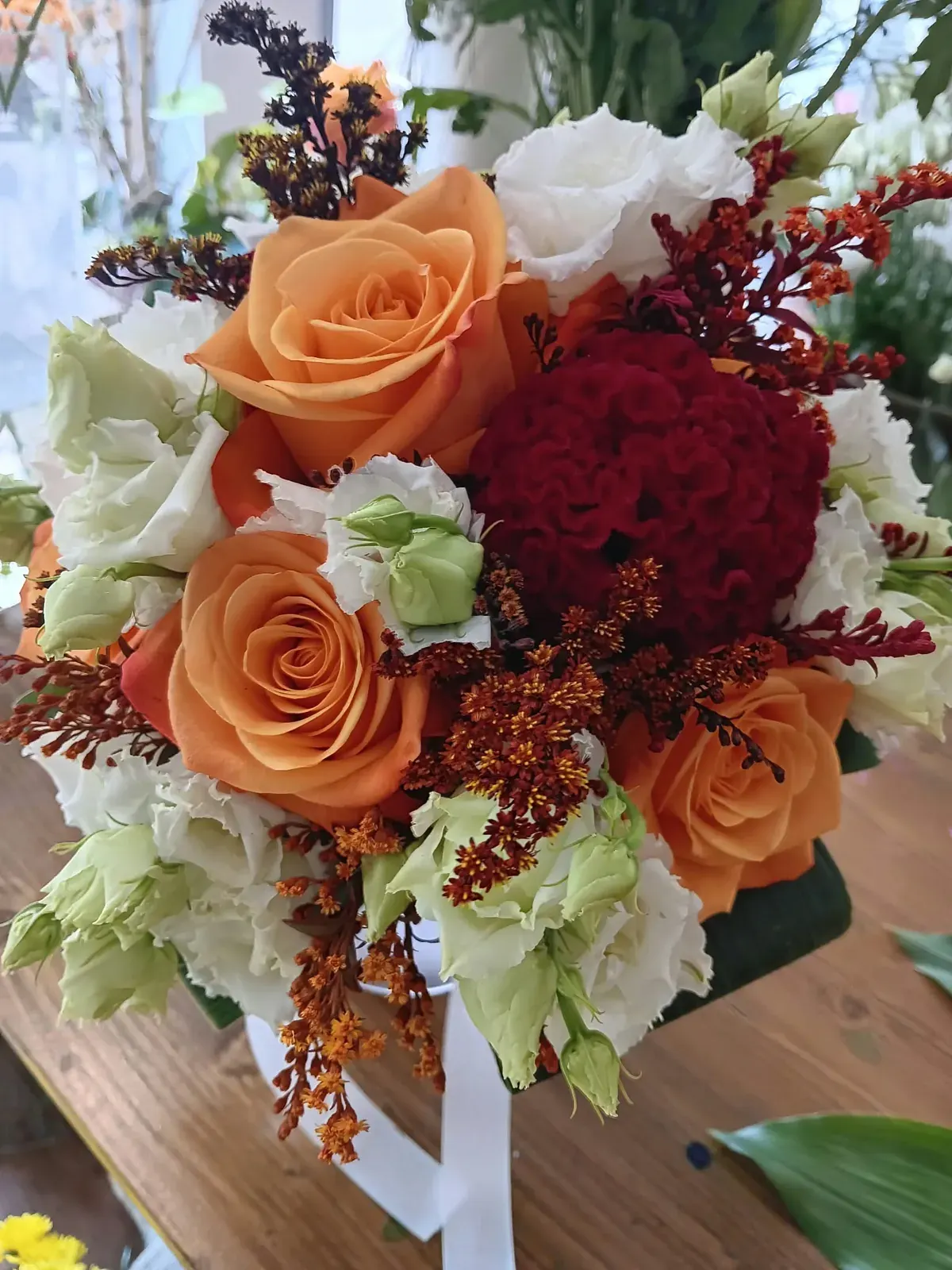 Bouquet di rose arancioni e rosse con fiori bianchi