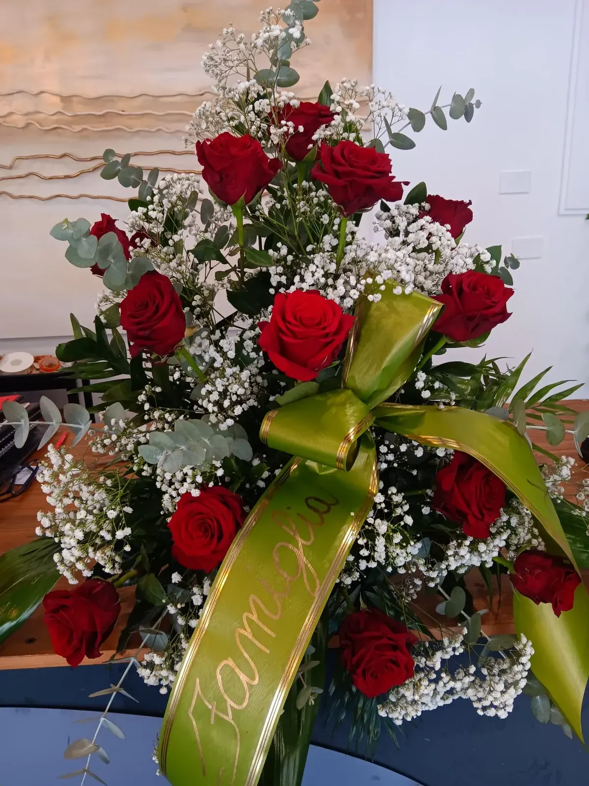 Composizione funebre rossa con piccoli fiori bianchi